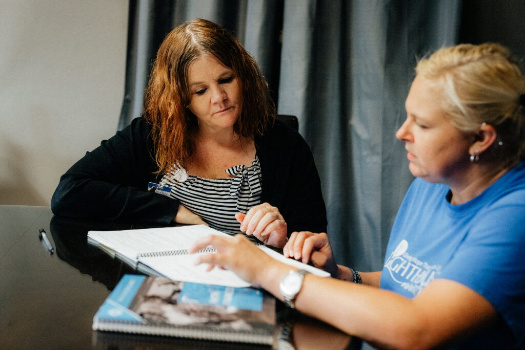 Two women discuss a financial literacy curriculum.